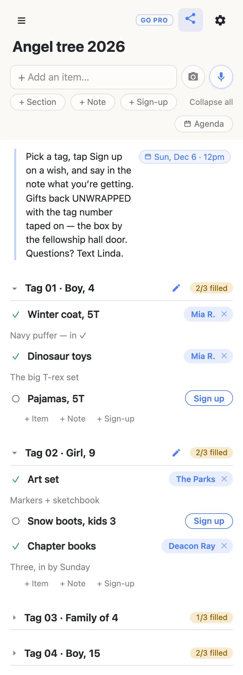 A phone showing a list titled “Angel tree 2026”. A note at the top, with a date chip reading Sun, Dec 6 · 12pm, says: Pick a tag, tap Sign up on a wish, and say in the note what you’re getting. Gifts back unwrapped with the tag number taped on — the box by the fellowship hall door. Questions? Text Linda. The section Tag 01 · Boy, 4 reads 2/3 filled: Mia R. has the Winter coat, 5T (“Navy puffer — in ✓”) and the Dinosaur toys (“The big T-rex set”); Pajamas, 5T still shows a Sign up button. Tag 02 · Girl, 9 reads 2/3 filled: The Parks have the Art set, Deacon Ray the Chapter books, and Snow boots, kids 3 is open. Tag 03 · Family of 4 (1/3 filled) and Tag 04 · Boy, 15 (2/3 filled) are folded shut.