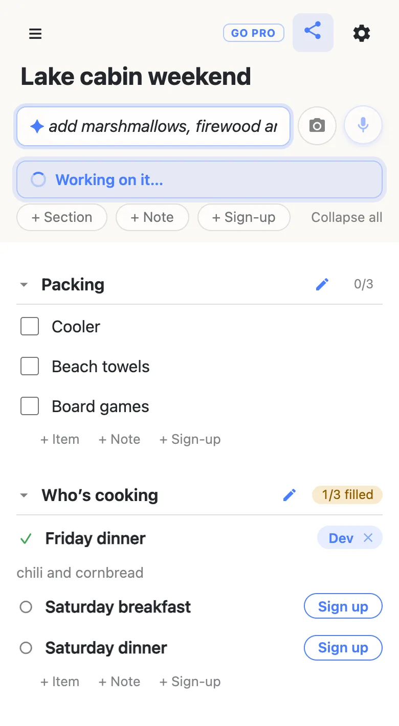 A shared list called Lake cabin weekend on a phone. The add box shows a ✦ and the start of a typed command, with a “Working on it…” status line beneath it; below are a Packing section with three items and a Who’s cooking section with three sign-up slots, one filled.
