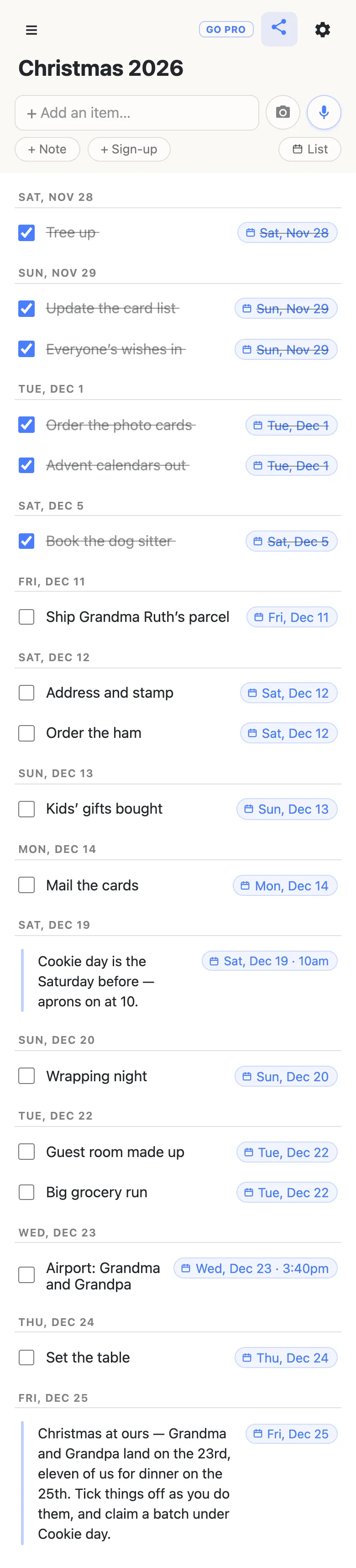 The same Christmas 2026 list in Agenda view, with a List button where the Agenda button was. Rows from every section are grouped under date headings. Sat, Nov 28: Tree up, ticked. Sun, Nov 29: Update the card list and Everyone’s wishes in, both ticked. Tue, Dec 1: Order the photo cards and Advent calendars out, both ticked. Sat, Dec 5: Book the dog sitter, ticked. Fri, Dec 11: Ship Grandma Ruth’s parcel. Sat, Dec 12: Address and stamp, and Order the ham. Sun, Dec 13: Kids’ gifts bought. Mon, Dec 14: Mail the cards. Sat, Dec 19: the note Cookie day is the Saturday before — aprons on at 10, at 10am. Sun, Dec 20: Wrapping night. Tue, Dec 22: Guest room made up and Big grocery run. Wed, Dec 23: Airport: Grandma and Grandpa at 3:40pm. Thu, Dec 24: Set the table. Fri, Dec 25: the note at the top of the list.