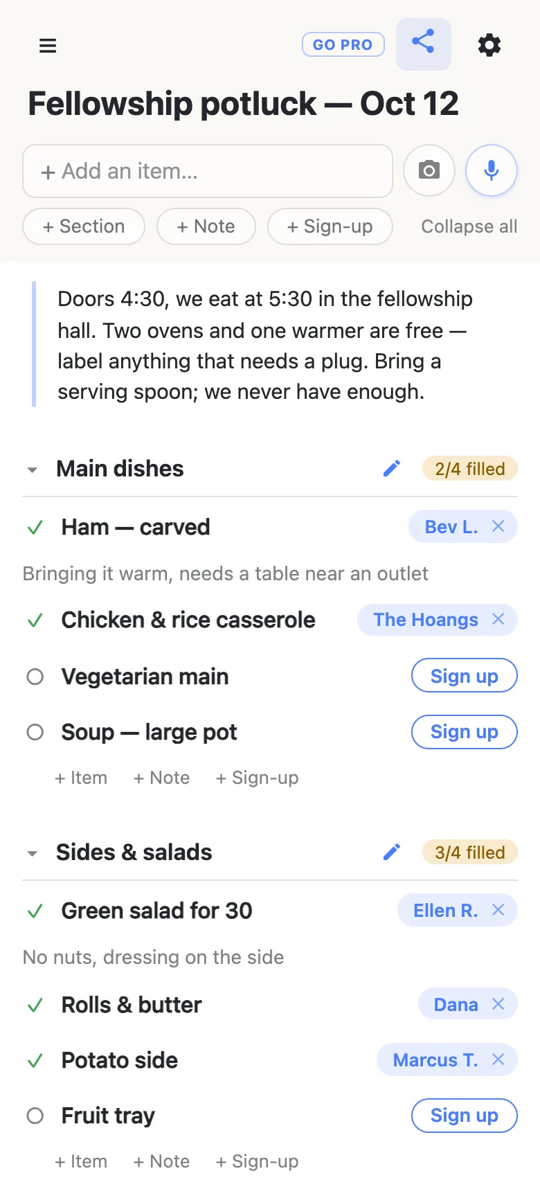 A phone showing a list titled “Fellowship potluck — Oct 12”. A note at the top gives the door and meal times, the ovens, and a reminder to bring a serving spoon. Main dishes reads 2/4 filled with the ham claimed by Bev L. and a note “Bringing it warm, needs a table near an outlet”; two rows below it still show Sign up buttons. Sides & salads reads 3/4 filled, with Ellen R. on the green salad and one fruit tray still open.