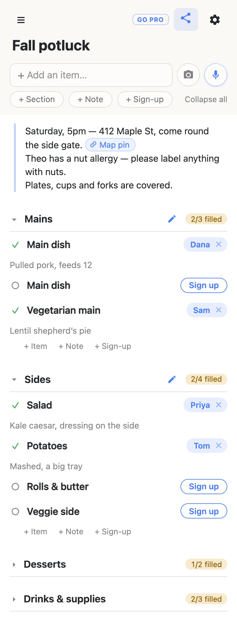 A phone showing a list titled “Fall potluck”. A note at the top says Saturday, 5pm at 412 Maple St, come round the side gate, with a Map pin link; Theo has a nut allergy, so please label anything with nuts; plates, cups and forks are covered. Mains reads 2/3 filled: Dana on Main dish with the note “Pulled pork, feeds 12”, a second Main dish still open, and Sam on Vegetarian main with “Lentil shepherd’s pie”. Sides reads 2/4 filled: Priya on Salad, Tom on Potatoes, and Rolls & butter and Veggie side still open. Desserts (1/2 filled) and Drinks & supplies (2/3 filled) are folded.
