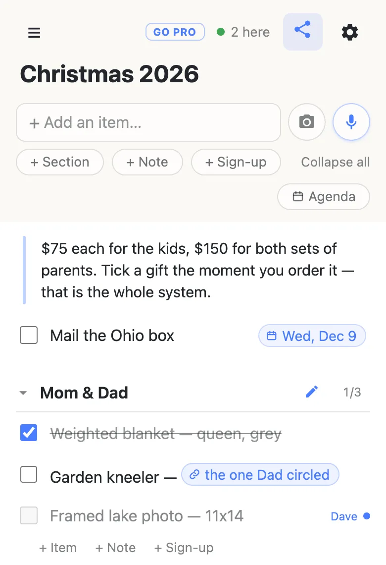 The top of the same Christmas 2026 list, with a green dot and “2 here” in the header. In the Mom & Dad section, the row Framed lake photo — 11x14 is dimmed and carries the name Dave with a pulsing dot beside it, showing he is typing on that row right now.