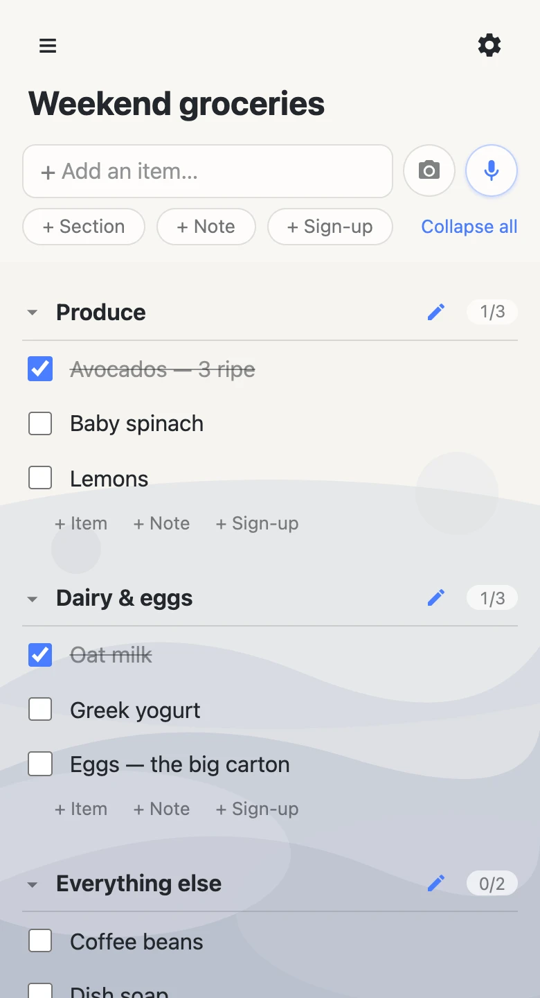 A shared grocery list open on a phone, with items grouped under Produce, Dairy & eggs, and Everything else. Avocados and oat milk are checked off and struck through.