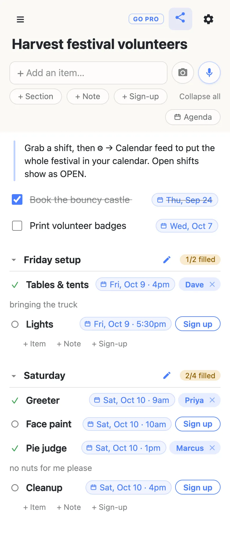 A sign-up sheet titled “Harvest festival volunteers” on a phone. A note at the top reads “Grab a shift, then ⚙ → Calendar feed to put the whole festival in your calendar. Open shifts show as OPEN.” A checked item, Book the bouncy castle, carries Thu, Sep 24; Print volunteer badges carries Wed, Oct 7. Friday setup reads 1/2 filled: Tables & tents, Fri, Oct 9 · 4pm, taken by Dave with the note “bringing the truck”, and Lights, Fri, Oct 9 · 5:30pm, open with a Sign up button. Saturday reads 2/4 filled: Greeter at 9am taken by Priya, Face paint at 10am open, Pie judge at 1pm taken by Marcus with the note “no nuts for me please”, and Cleanup at 4pm open.