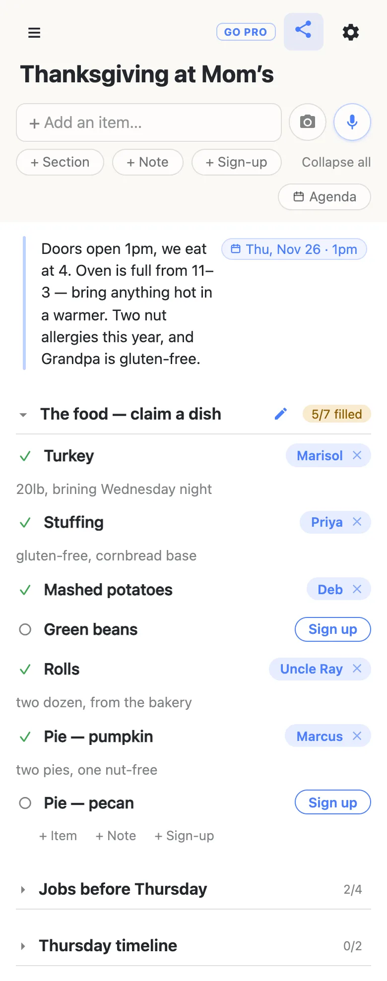 A phone showing a list titled “Thanksgiving at Mom’s”. A note at the top, with a date chip reading Thu, Nov 26 · 1pm, says: Doors open 1pm, we eat at 4. Oven is full from 11–3 — bring anything hot in a warmer. Two nut allergies this year, and Grandpa is gluten-free. Below it the section “The food — claim a dish” carries an amber 5/7 filled counter; claimed rows show Marisol on the Turkey (“20lb, brining Wednesday night”), Priya on the Stuffing (“gluten-free, cornbread base”), Deb, Uncle Ray and Marcus, while Green beans and Pie — pecan still show a blue Sign up button. Jobs before Thursday (2/4) and Thursday timeline (0/2) are folded underneath.