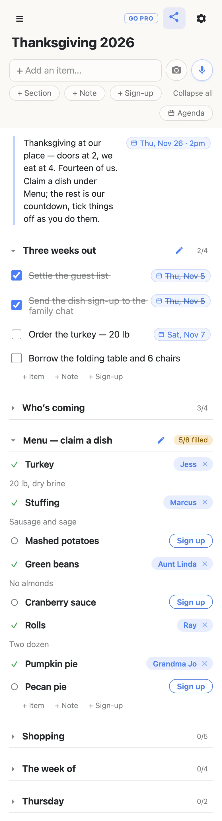 A phone showing a list titled “Thanksgiving 2026”. A note at the top, with a date chip reading Thu, Nov 26 · 2pm, says: Thanksgiving at our place — doors at 2, we eat at 4. Fourteen of us. Claim a dish under Menu; the rest is our countdown, tick things off as you do them. The section Three weeks out reads 2/4: Settle the guest list and Send the dish sign-up to the family chat are ticked and struck through, each with a Thu, Nov 5 chip; Order the turkey — 20 lb carries a Sat, Nov 7 chip; Borrow the folding table and 6 chairs is still open. Who’s coming, 3/4, is folded shut. Menu — claim a dish reads 5/8 filled: Jess has the Turkey (“20 lb, dry brine”), Marcus the Stuffing (“Sausage and sage”), Aunt Linda the Green beans (“No almonds”), Ray the Rolls (“Two dozen”) and Grandma Jo the Pumpkin pie, while Mashed potatoes, Cranberry sauce and Pecan pie each show a Sign up button. Shopping (0/5), The week of (0/4) and Thursday (0/2) are folded shut underneath.